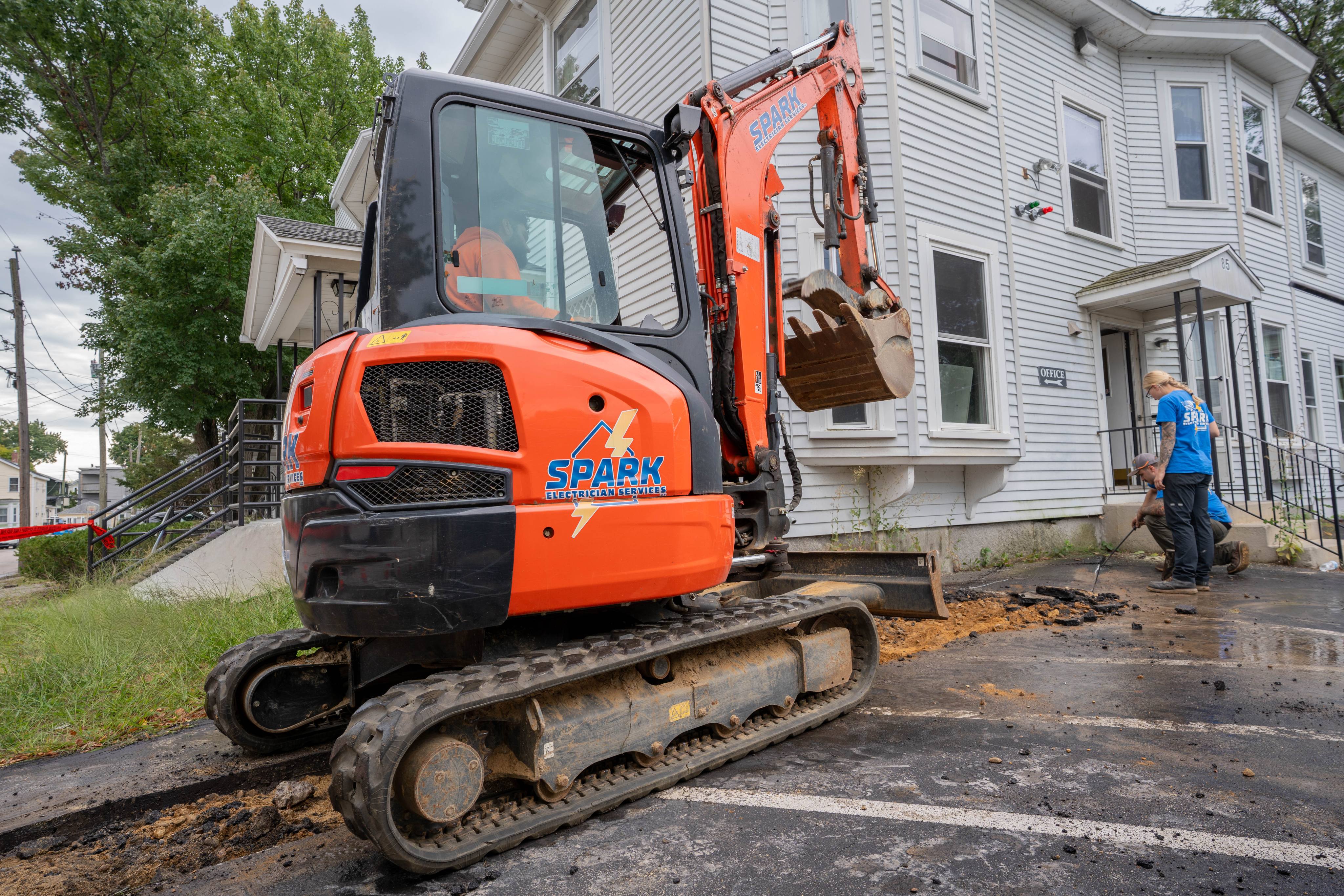Excavating the service trench along the building