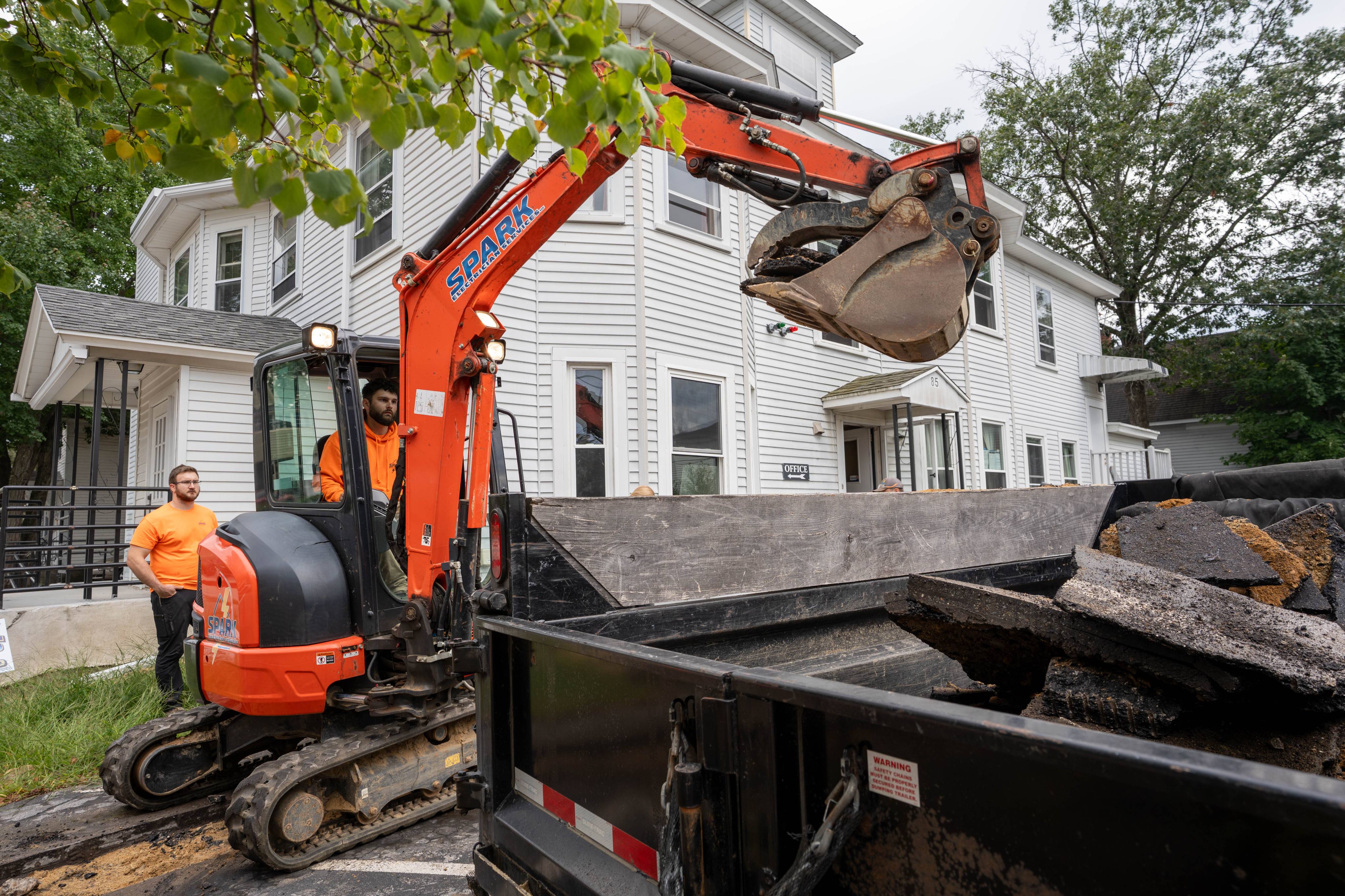 Excavating the service trench along the building