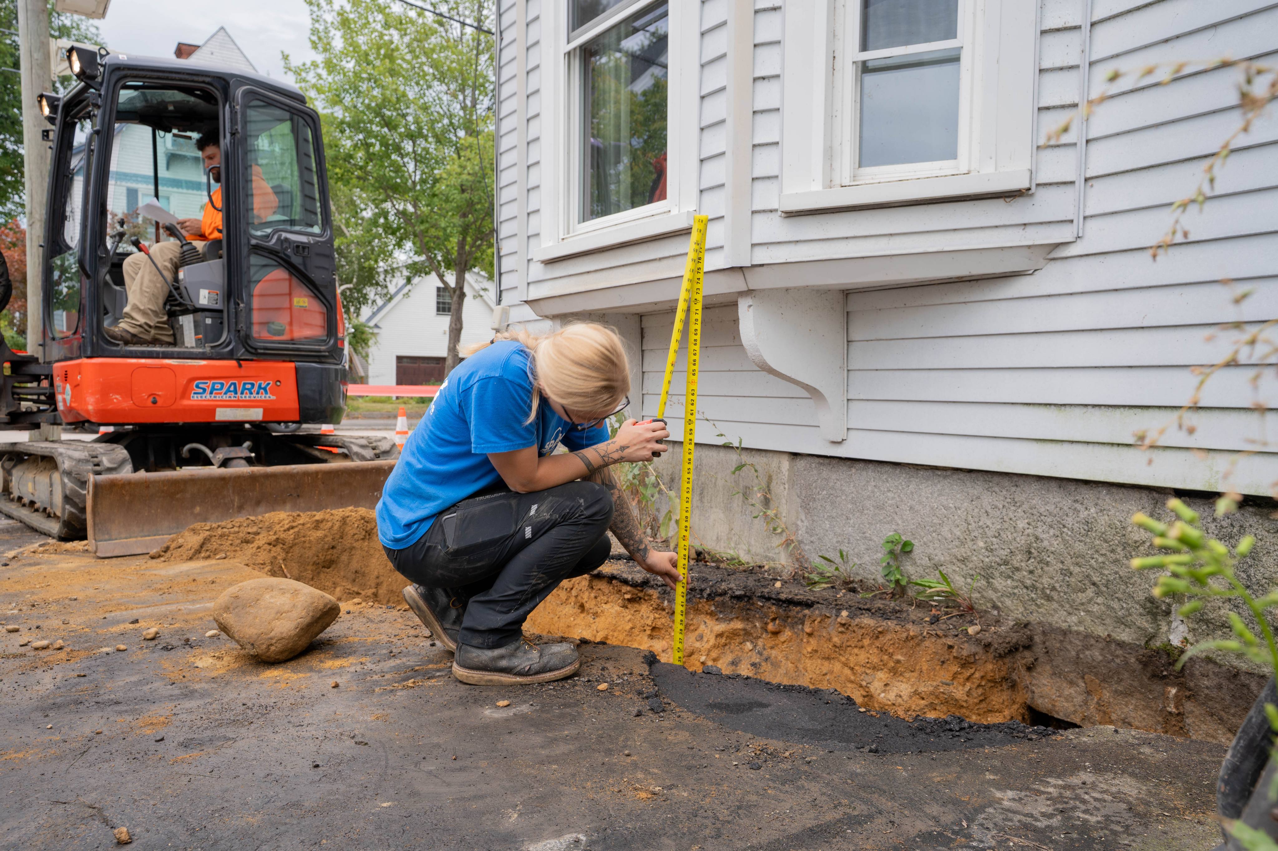 Excavating the service trench along the building
